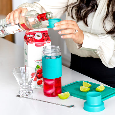 woman making a cocktail by adding vodka to the cap