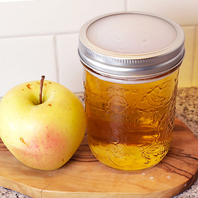 silicone disc on a mason jar with apple juice, secured with metal ring