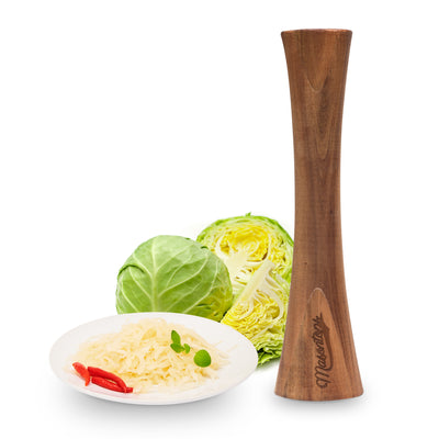A cabbage, a bowl of sourkraut and a pepper grinder